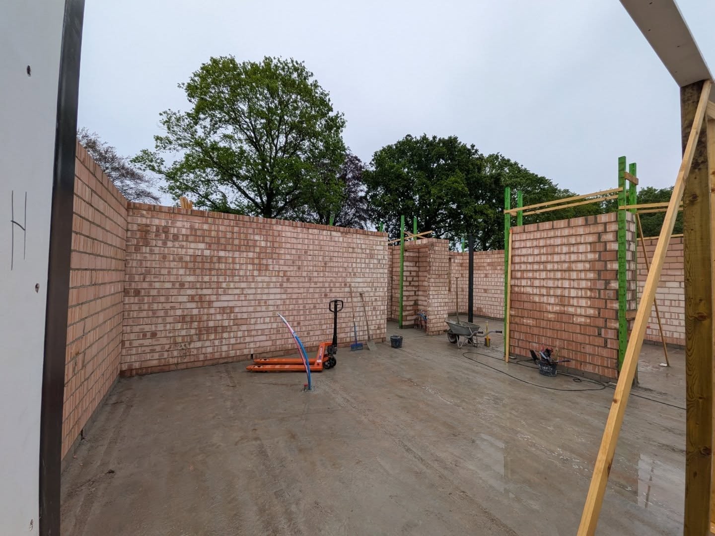 Begane grond van een nieuwbouwwoning met vers gemetselde muren in lichtrode steen